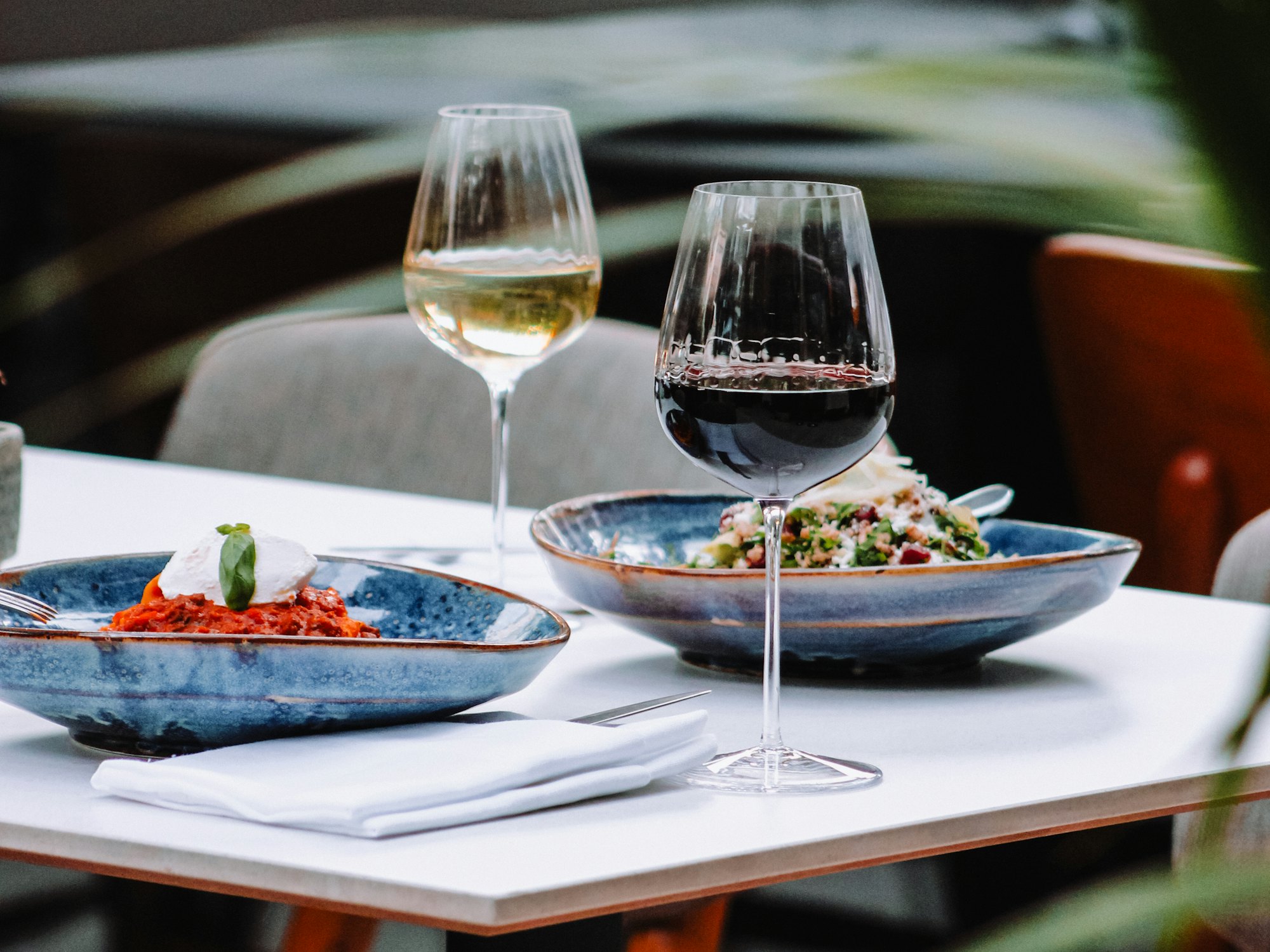 Restaurant table set with shared plates and glasses of wine