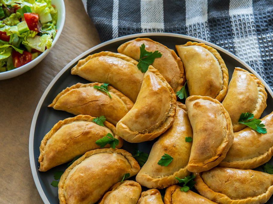 Baked beef empanadas on a plate with salad