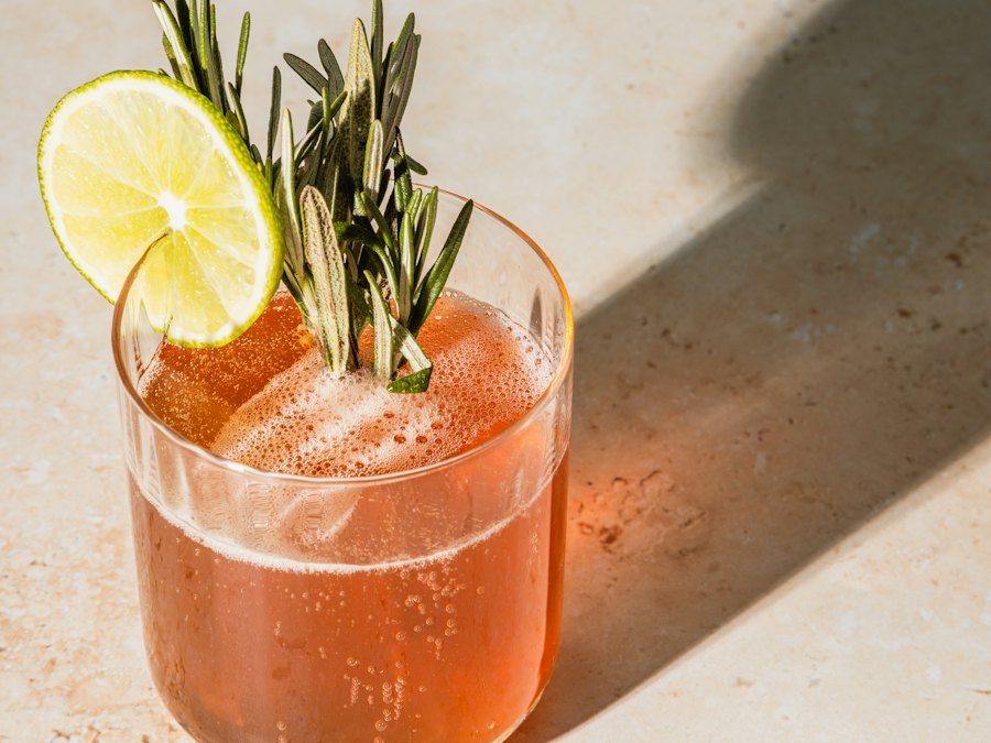Cocktail garnished with lime and rosemary