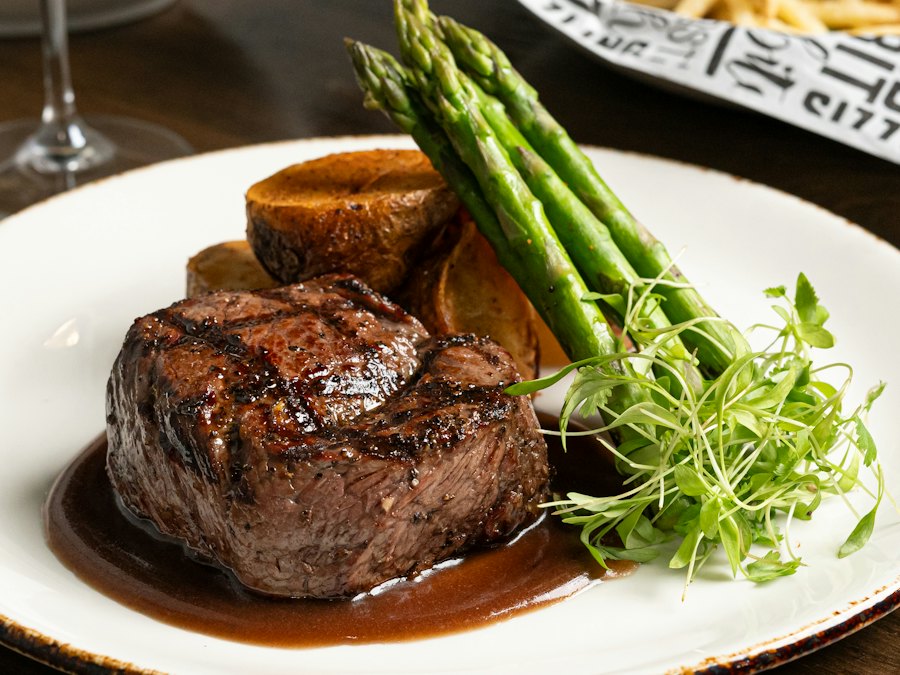 Plated steak with asparagus and a glass of red wine