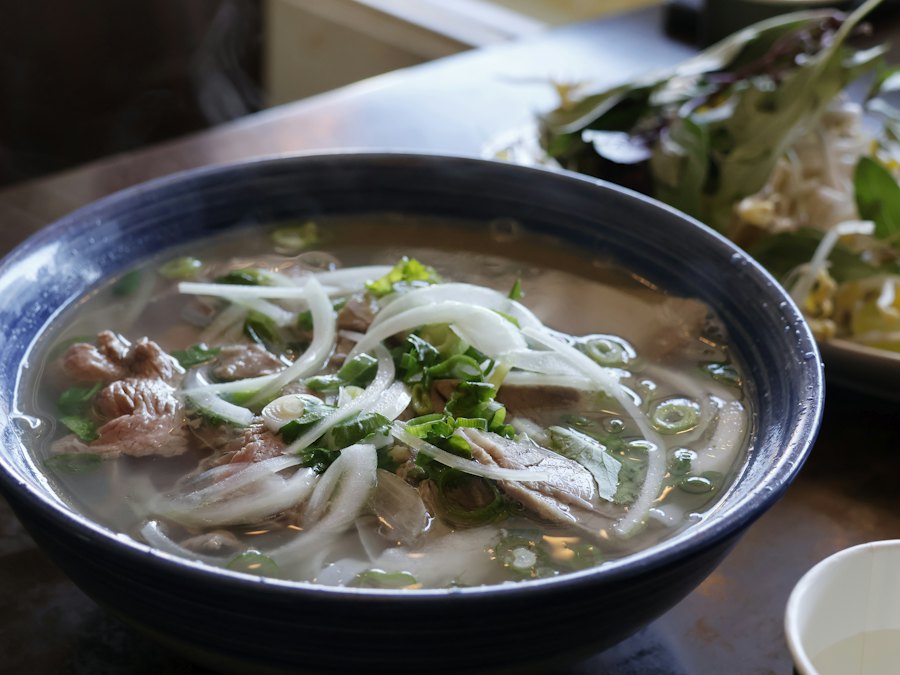 Bowl of Vietnamese beef pho with rice noodles and herbs