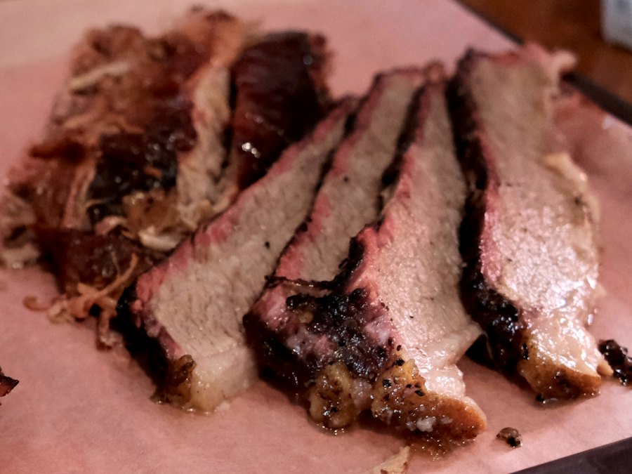 Sliced smoked brisket on pink butcher paper