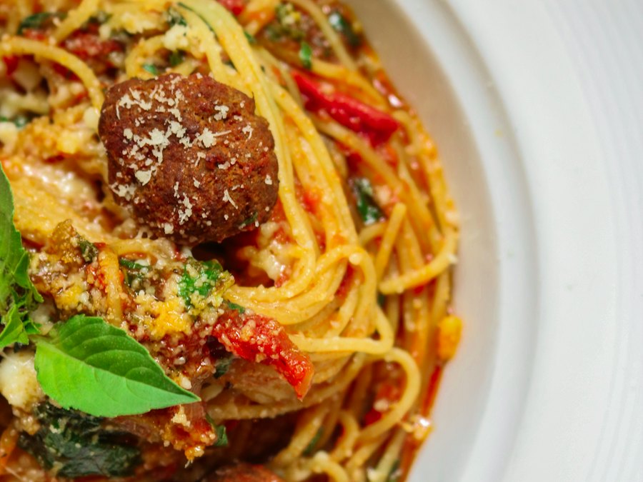 Spaghetti and meatballs in tomato sauce on a white plate