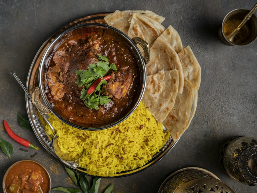 Bowl of curry served with rice and naan